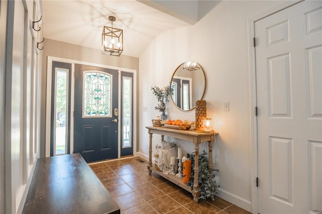 tiled foyer with an inviting chandelier