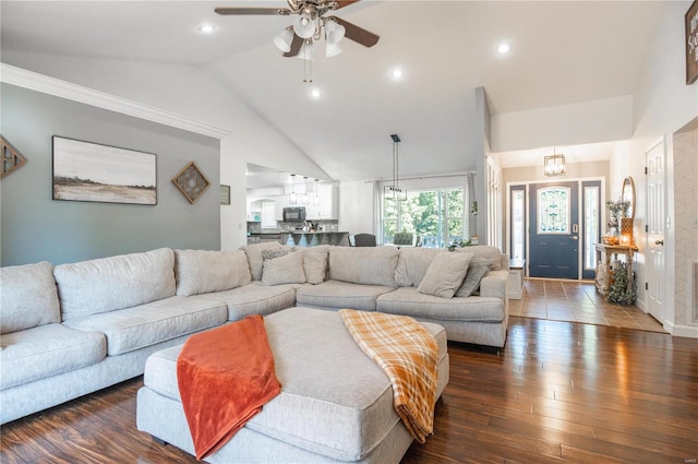 living room featuring dark wood-type flooring, ceiling fan with notable chandelier, lofted ceiling, and crown molding