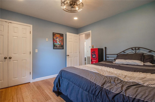 bedroom with an inviting chandelier, a closet, and light hardwood / wood-style floors