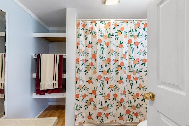 bathroom with ornamental molding, a shower with shower curtain, and hardwood / wood-style flooring