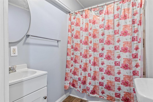 bathroom with walk in shower, hardwood / wood-style floors, vanity, and toilet