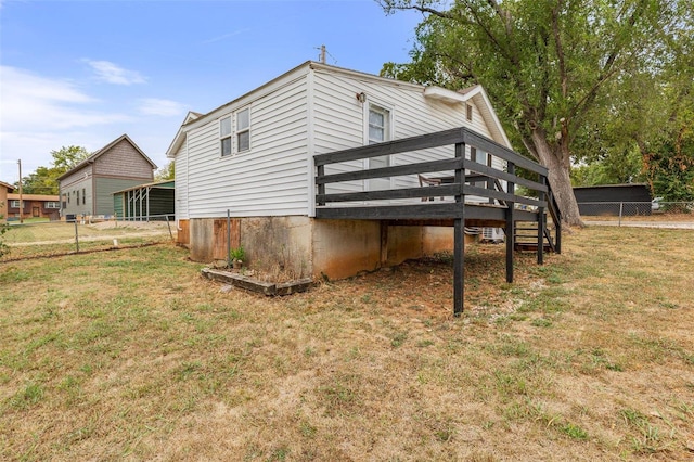 rear view of house with a lawn and a deck