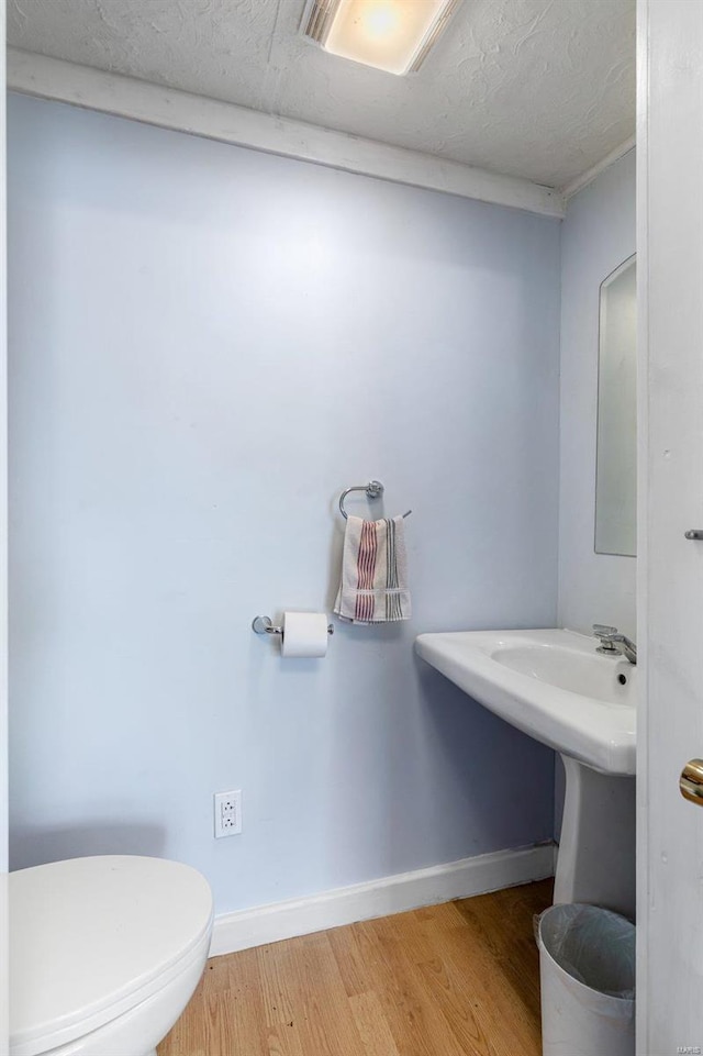 bathroom featuring hardwood / wood-style flooring, toilet, and a textured ceiling