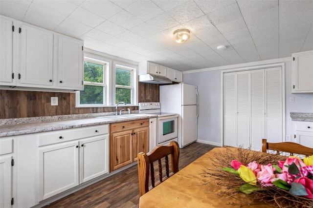 kitchen with white appliances, sink, dark wood-type flooring, and white cabinets