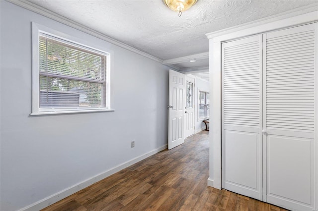 hall with a textured ceiling, dark hardwood / wood-style floors, and crown molding