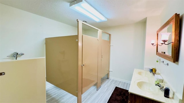 bathroom featuring a textured ceiling, vanity, a shower with door, and hardwood / wood-style floors