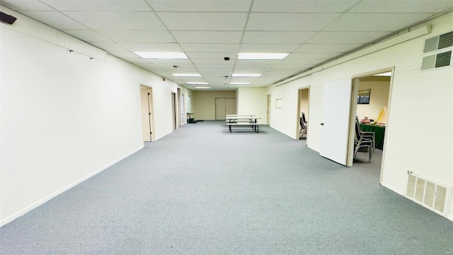 interior space with a paneled ceiling and carpet