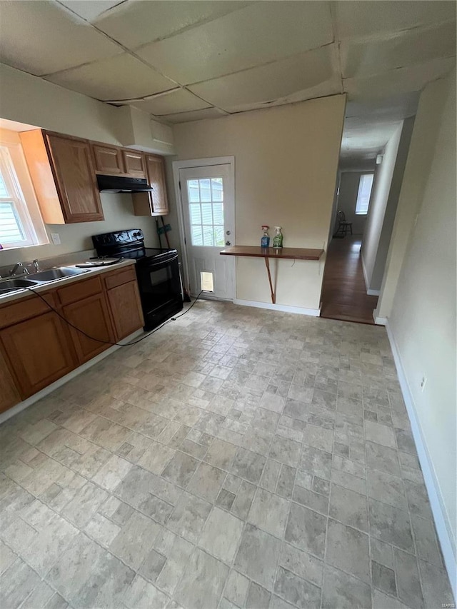 kitchen with a paneled ceiling, electric range, and sink