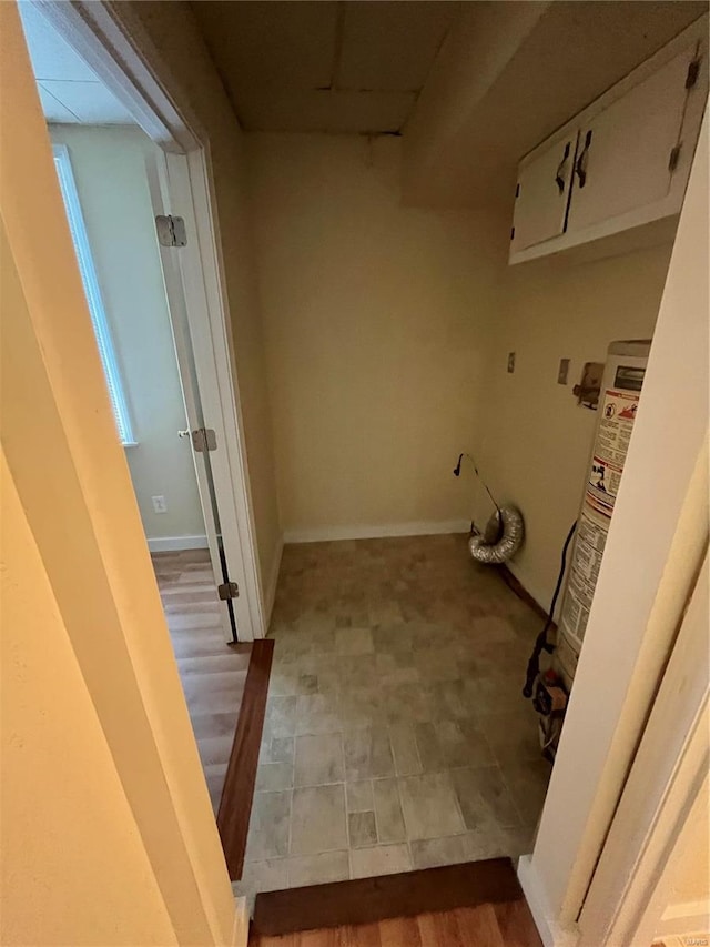 washroom featuring cabinets, tile patterned floors, and water heater