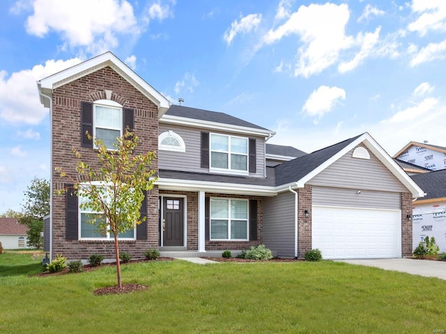 traditional-style home featuring a front yard, concrete driveway, brick siding, and a garage