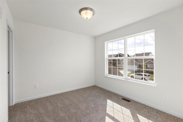 empty room featuring visible vents, carpet, and baseboards