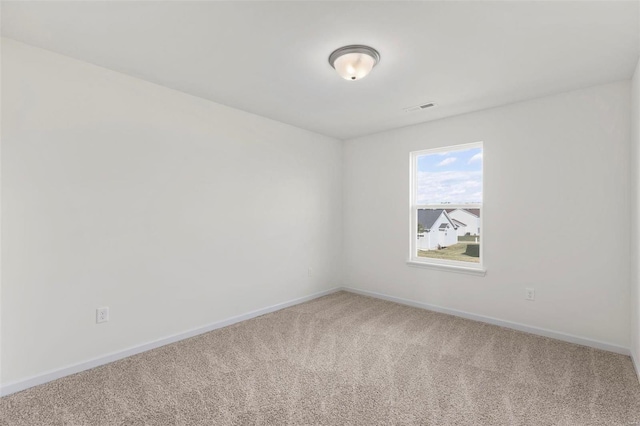 carpeted spare room featuring visible vents and baseboards