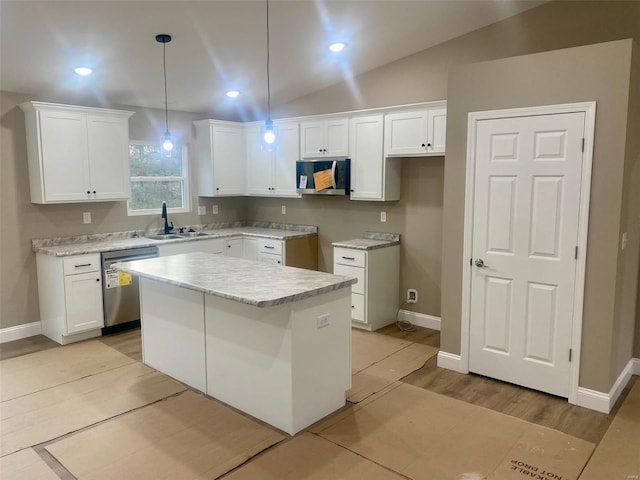 kitchen featuring a sink, white cabinetry, light countertops, appliances with stainless steel finishes, and a center island