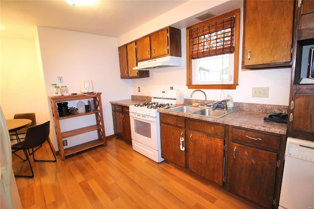 kitchen with white appliances, light hardwood / wood-style flooring, and sink