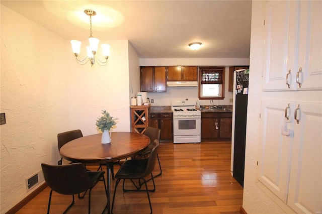 dining room featuring wood-type flooring, a chandelier, and sink