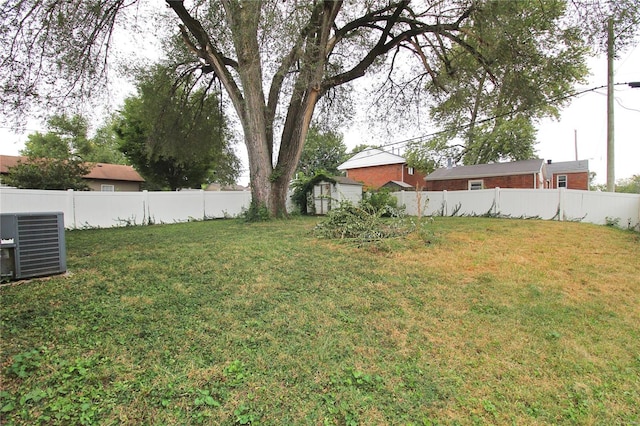 view of yard featuring central AC and a storage unit