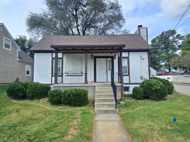 bungalow featuring covered porch and a front yard