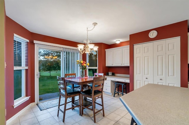 tiled dining area featuring an inviting chandelier and plenty of natural light