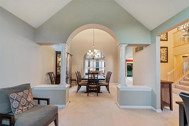 dining area featuring light carpet, high vaulted ceiling, and a chandelier