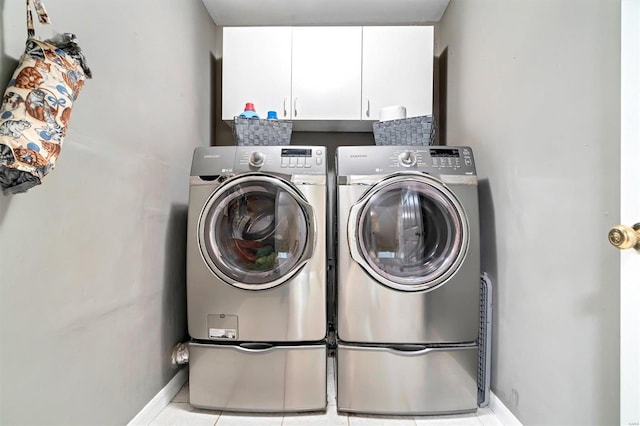 washroom featuring cabinets, independent washer and dryer, and light tile patterned floors