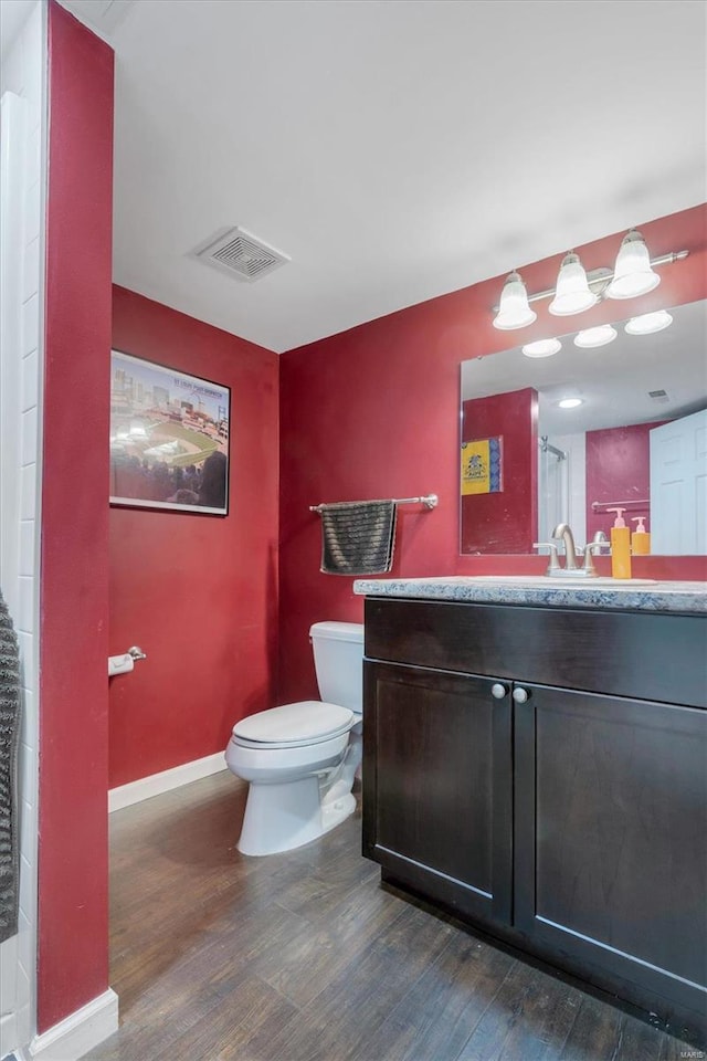 bathroom with vanity, toilet, and wood-type flooring