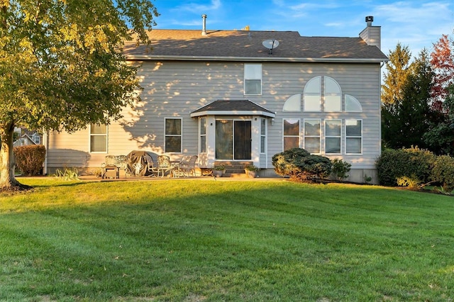 view of front of home featuring a front lawn and a patio area