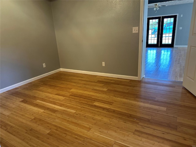 empty room with french doors and light hardwood / wood-style floors