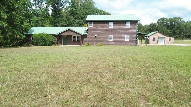 back of house with a lawn and an outbuilding