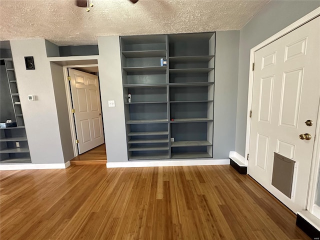 spare room featuring a textured ceiling and wood-type flooring