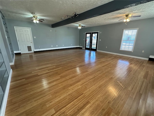 spare room featuring ceiling fan, beamed ceiling, hardwood / wood-style flooring, and a textured ceiling