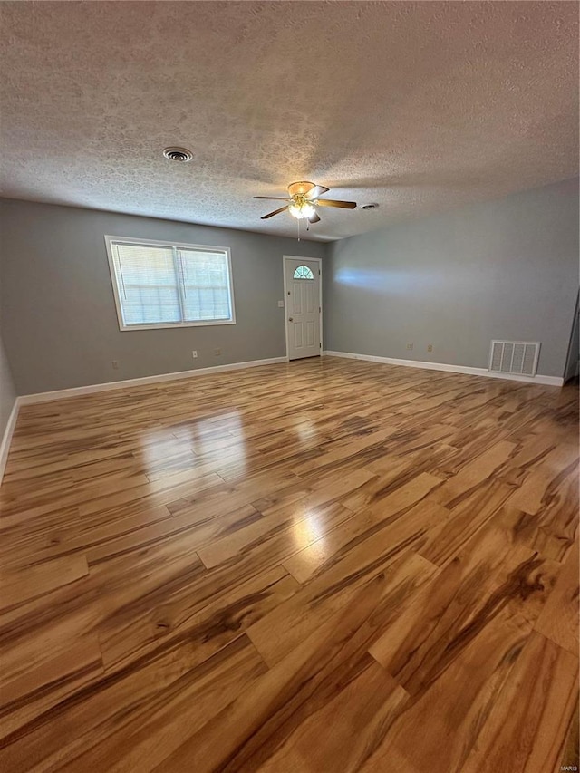 unfurnished room with light hardwood / wood-style flooring, ceiling fan, and a textured ceiling