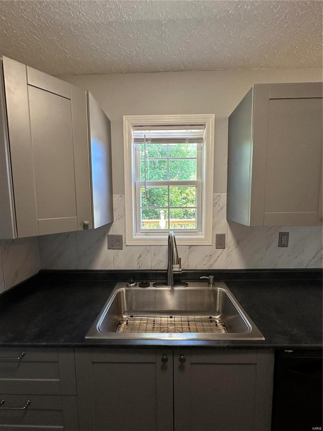 kitchen with gray cabinets, decorative backsplash, a textured ceiling, and sink