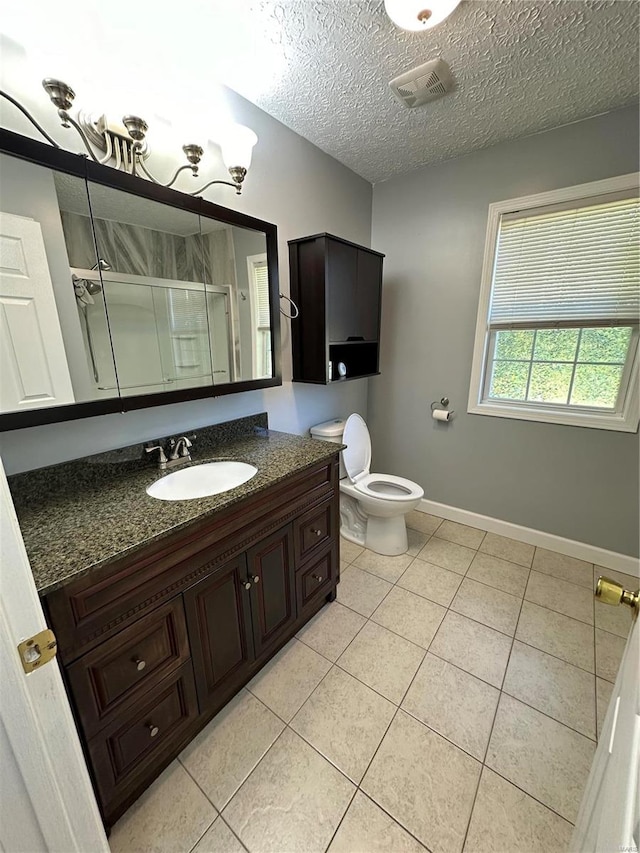 bathroom with tile patterned floors, a shower with shower door, vanity, and toilet