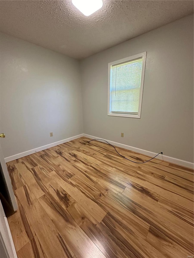 empty room featuring a textured ceiling and hardwood / wood-style flooring