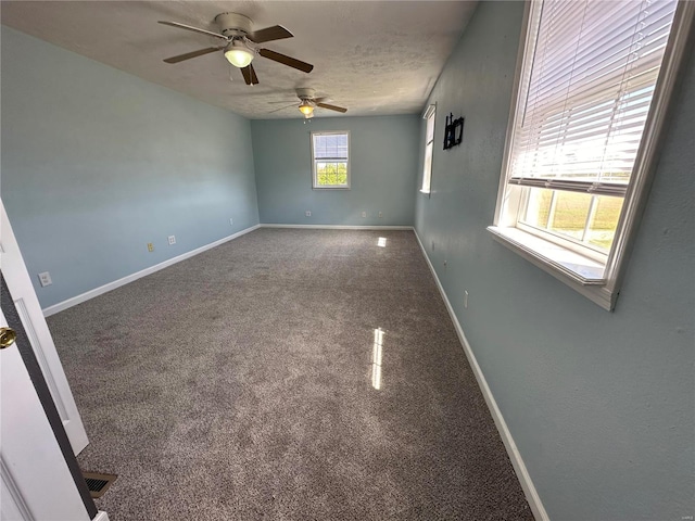 carpeted spare room with a textured ceiling and ceiling fan