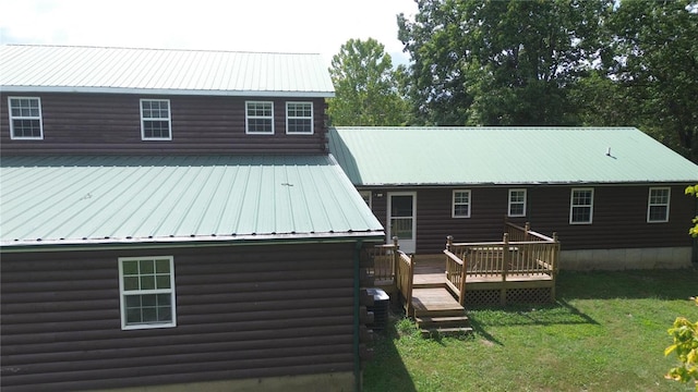 back of property featuring a lawn and a wooden deck