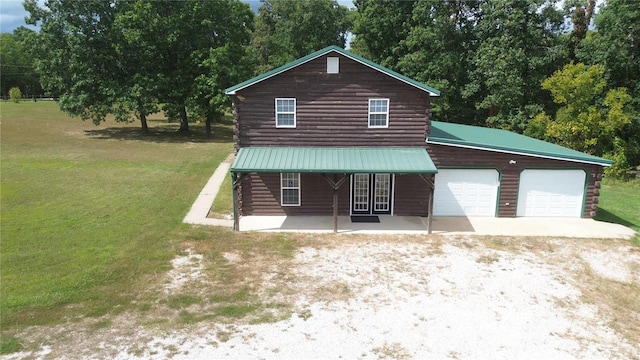 log cabin with a garage and a front lawn