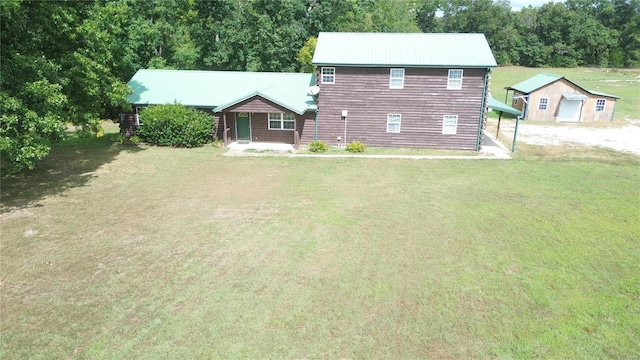 rear view of house with a lawn and a storage shed