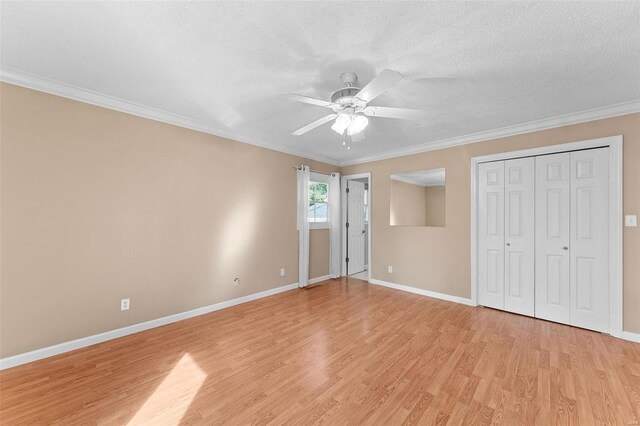 unfurnished bedroom featuring ceiling fan, a textured ceiling, light hardwood / wood-style flooring, a closet, and crown molding