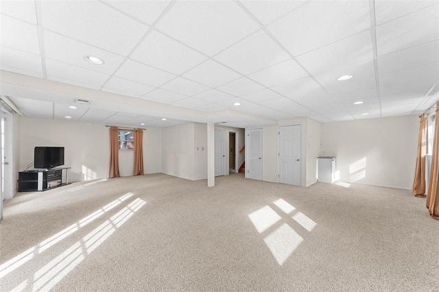 basement featuring carpet floors and a drop ceiling