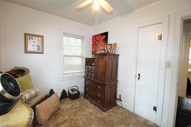 living area featuring carpet flooring and ceiling fan