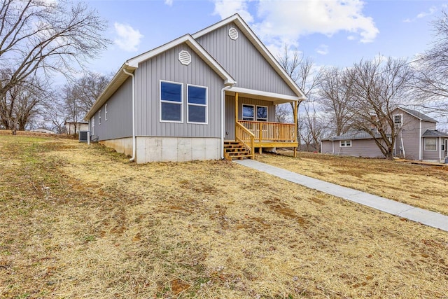 view of front facade featuring covered porch, a front lawn, and central air condition unit