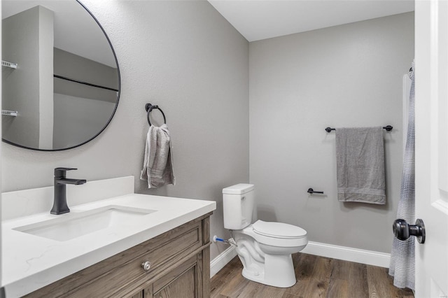 bathroom featuring wood-type flooring, vanity, and toilet