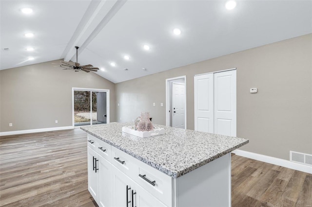 kitchen featuring white cabinetry, a center island, light hardwood / wood-style floors, and vaulted ceiling with beams