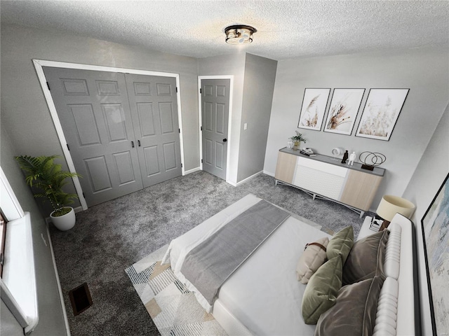 carpeted bedroom featuring a textured ceiling and a closet