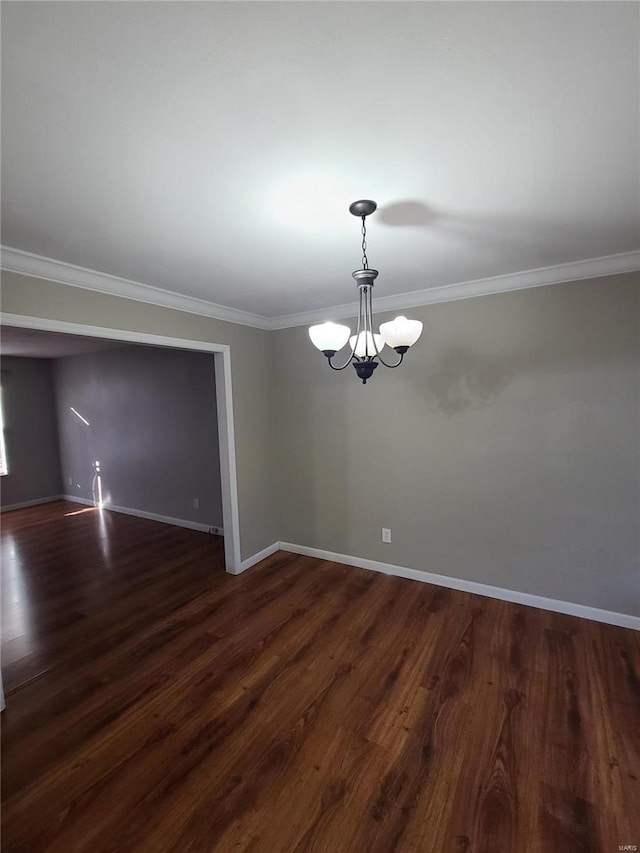 unfurnished room with ornamental molding, dark hardwood / wood-style floors, and an inviting chandelier