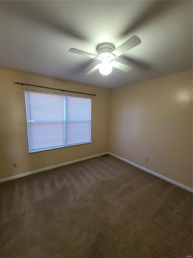 unfurnished room featuring ceiling fan and dark carpet