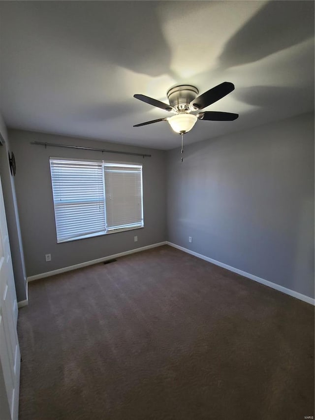 carpeted spare room featuring ceiling fan