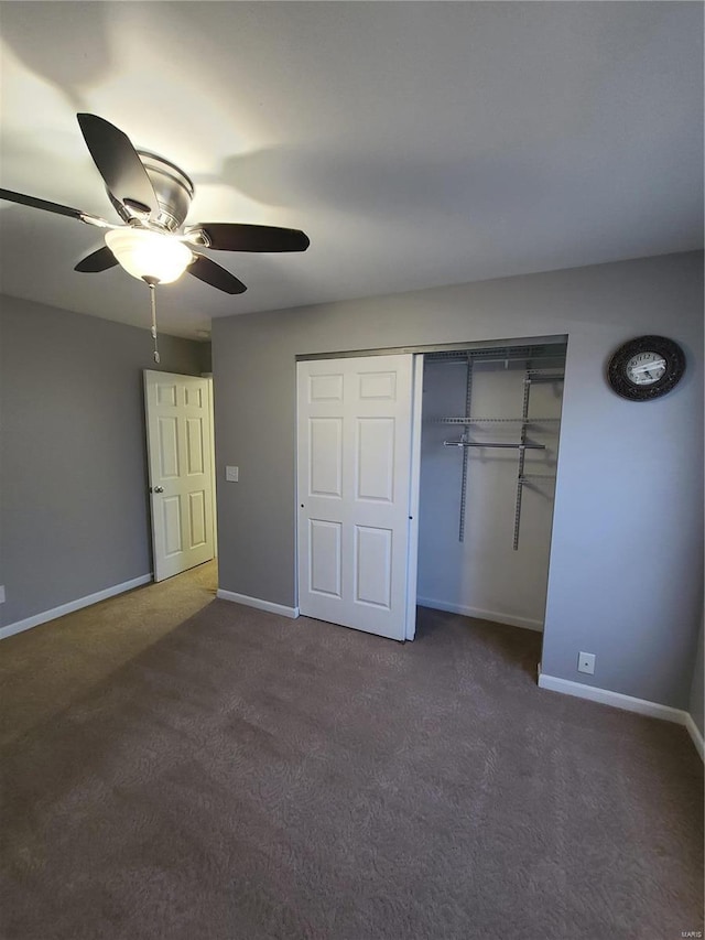 unfurnished bedroom with a closet, dark carpet, and ceiling fan