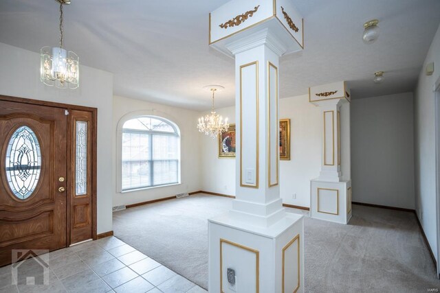 carpeted foyer entrance with an inviting chandelier and ornate columns